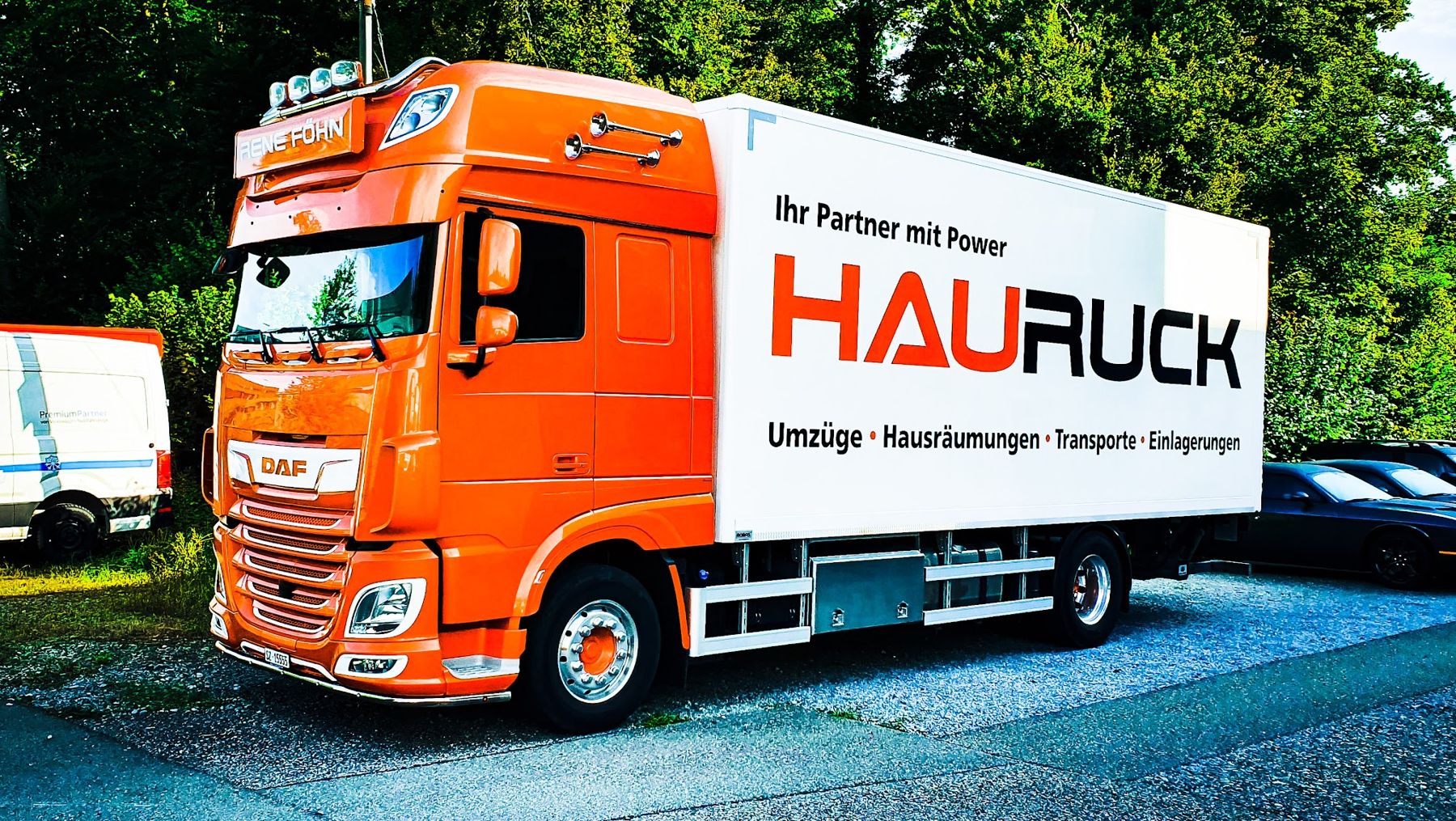 Oranger HAURUCK-Lastwagen von vorne mit Beschriftung Umzüge, Hausräumungen, Transporte, Entsorgungen