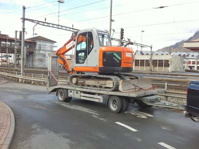 Orange Bagger auf einem Tieflader am Bahnhof