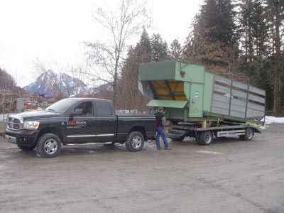 Grüner Zerkleinerer auf einem Anhänger hinter dem Pick-up
