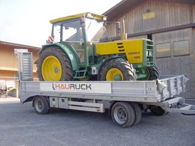 Traktor auf einem Anhänger mit HAURUCK-Schriftzug